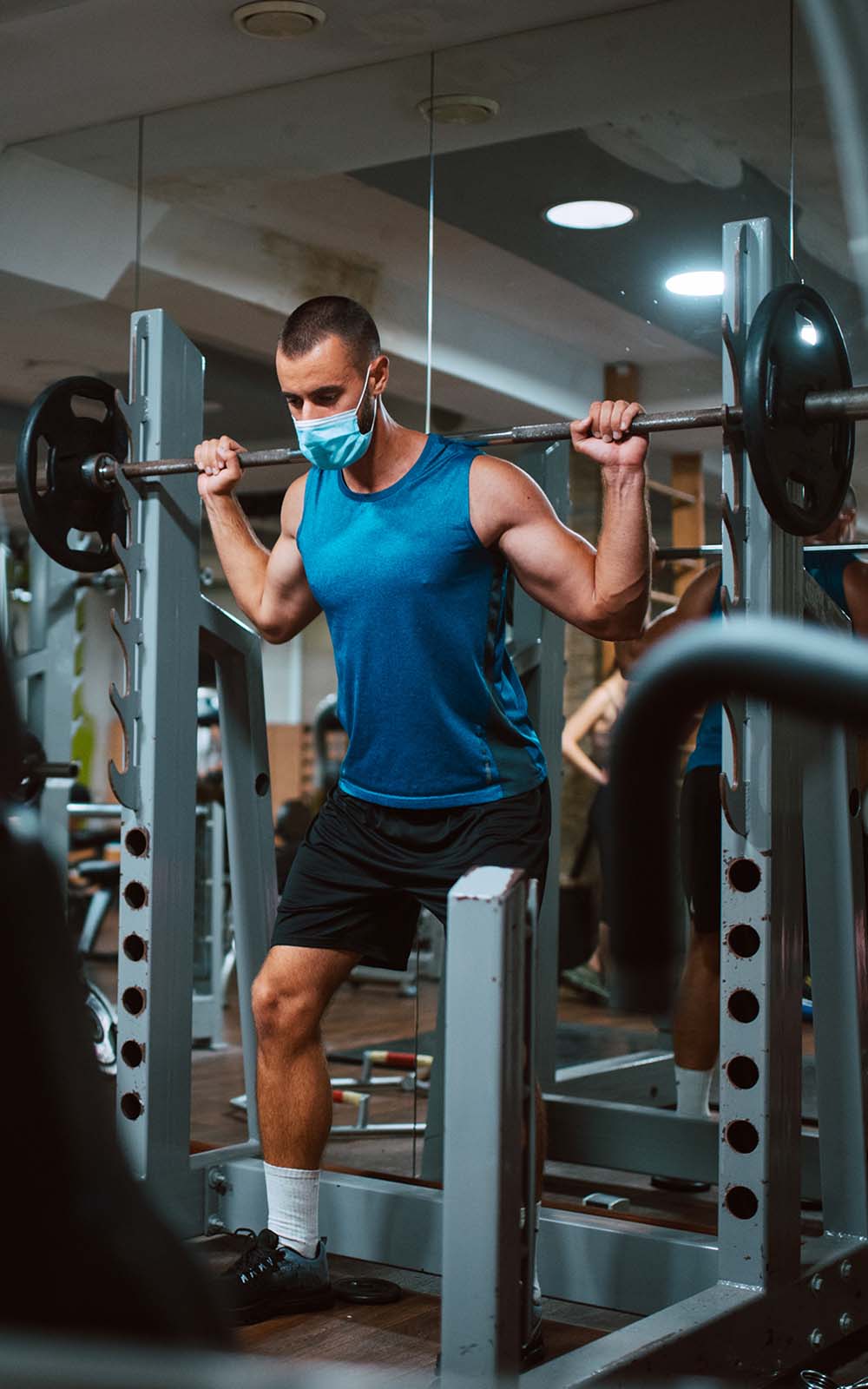Masked male lifting weights